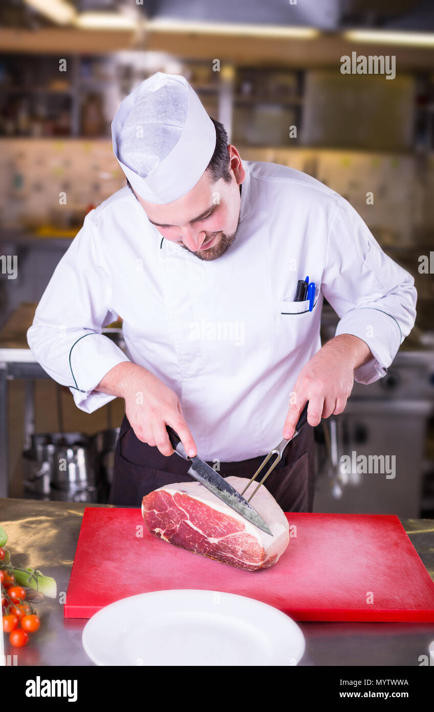 Male chef cutting big piece of meat Stock Photo - Alamy