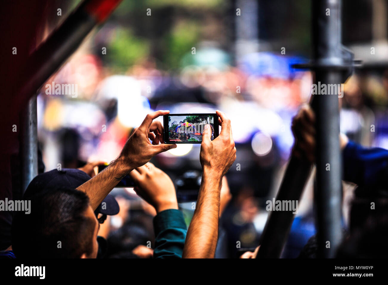 Mexico City, Mexico - June 27, 2015: Spectator taking video to Gustavo Vildosola at his Ford SVT Raptor Trophy Truck driving around the Zocalo Square and 20 de Noviembre street, at the Infiniti Red Bull Racing F1 Showrun. Stock Photo