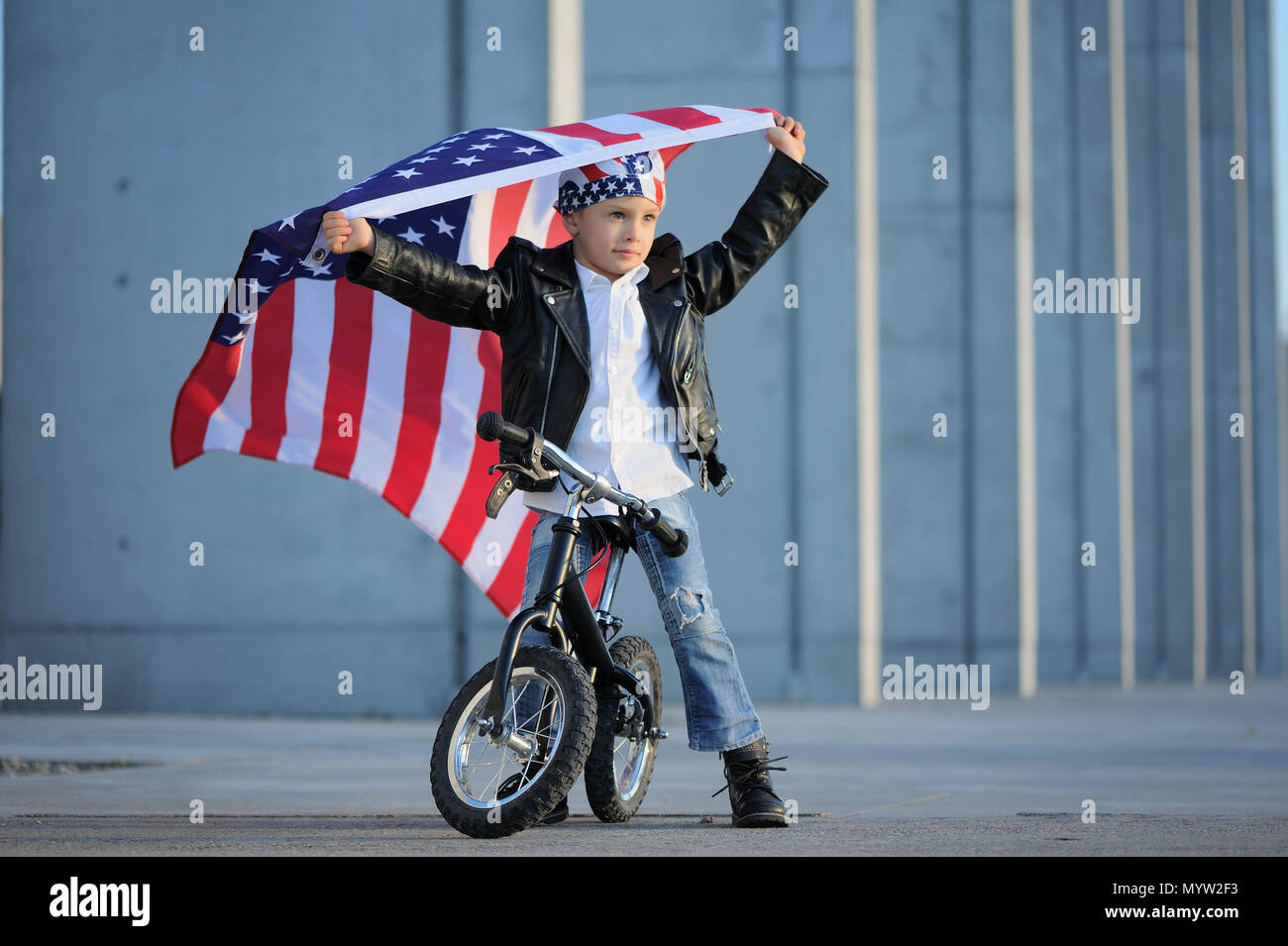 Happy handsome boy  smiling and waving American flag outside, wearing  Jackster Bandana. Child celebrating 4th july - Independence Day of USA. Stock Photo