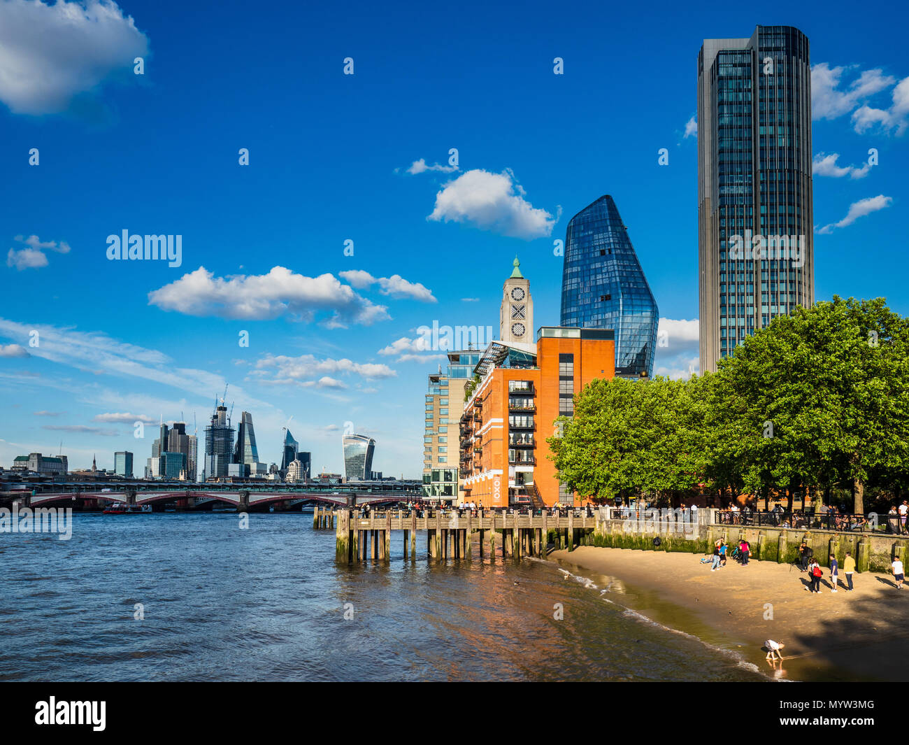 Thames Beach - people play and walk on the sandy beach on the River Thames on London's Southbank - London Tourism Stock Photo