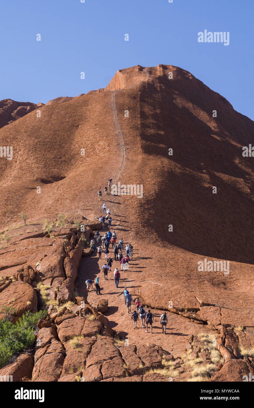 Walking up Uluru, or Ayer's Rock in Outback Australia.  The practice is unpopular with Traditional Owners of the land and will be banned in 2019 Stock Photo