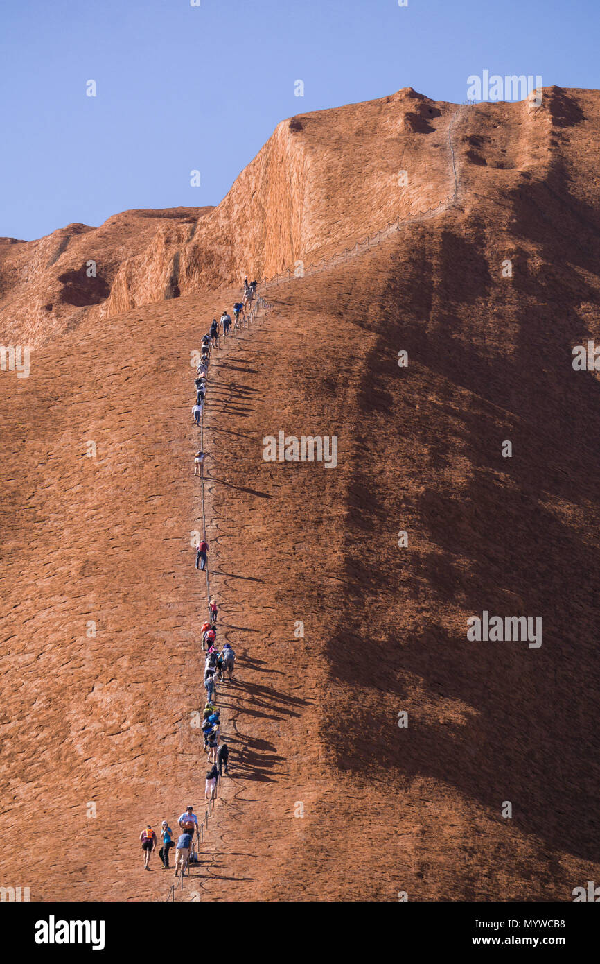 Walking up Uluru, or Ayer's Rock in Outback Australia.  The practice is unpopular with Traditional Owners of the land and will be banned in 2019 Stock Photo