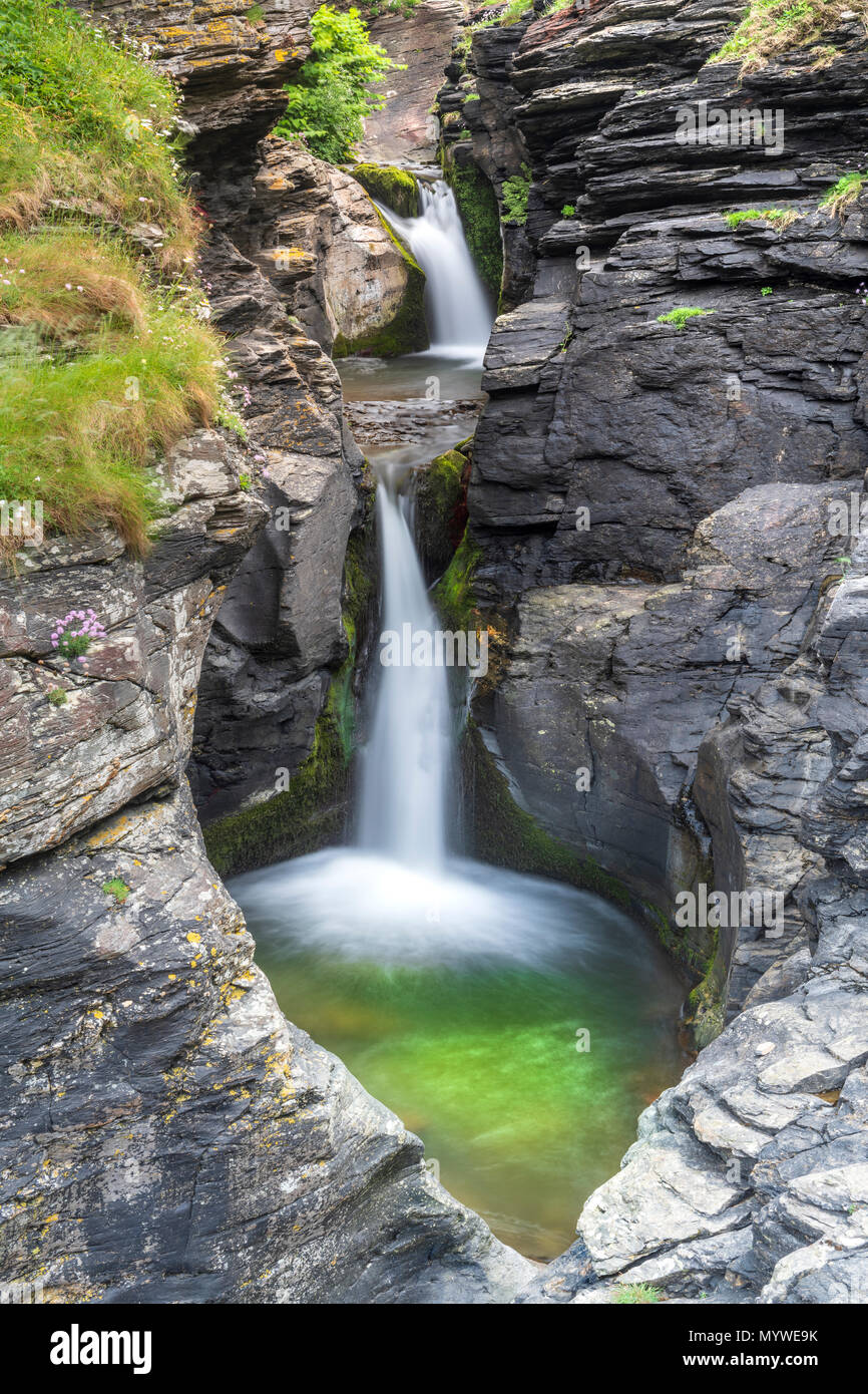 Water cascades over one of the picturesque waterfalls at St. Nectan's Glen near Bossiney Cove in North Cornwall. Stock Photo