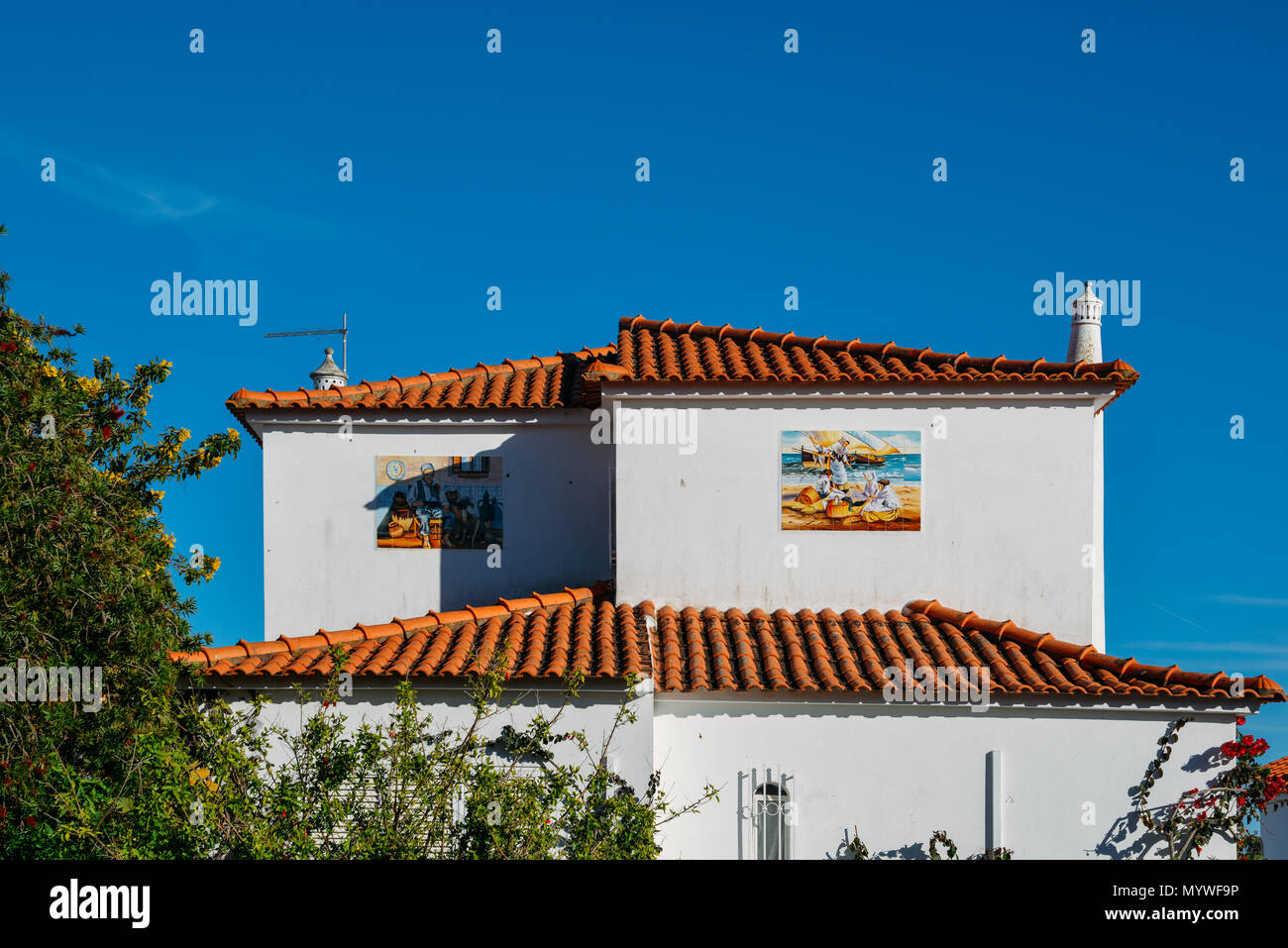 Tile drawings on a side of a building depicting Portuguese culture including life near the seaside Stock Photo