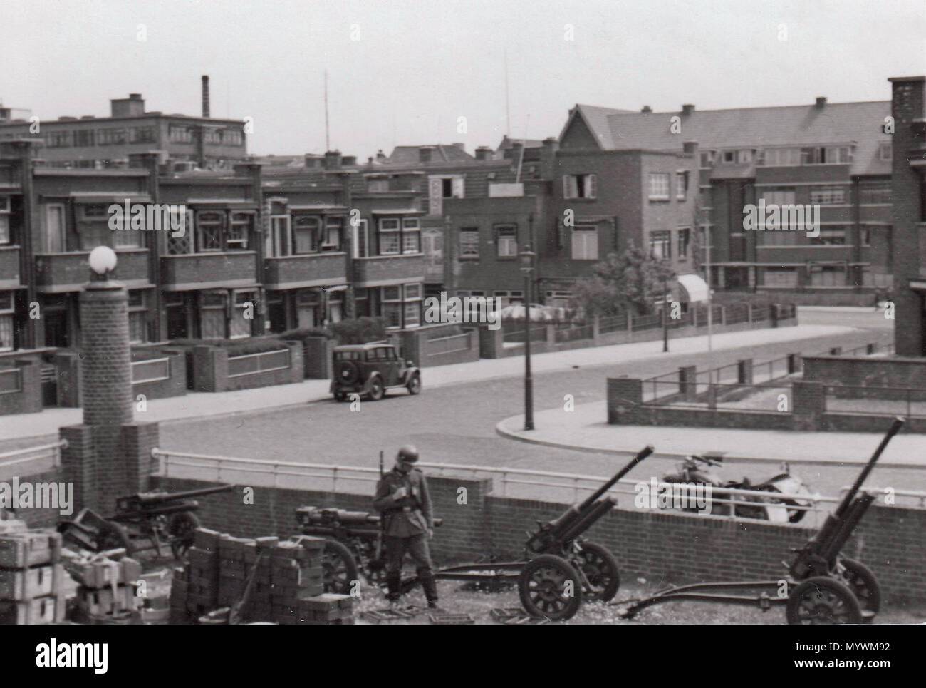 . English: A German soldier standing guard by artillery, in the garden of the Von Wied pavilion, with a view of the Harteveltstraat and Gevers Deynootweg, The Hague  . 1942. Anonymous 3 German soldier guards artillery in Scheveningen near Von Wied Pavillion Stock Photo