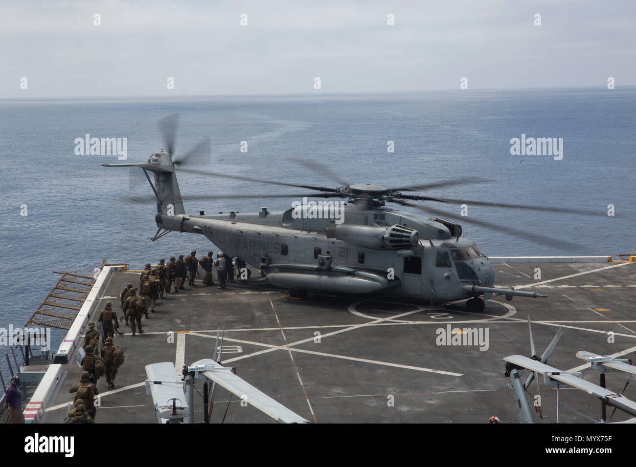 U.S. Marines with Combat Logistics Battalion 13, 13th Marine Expeditionary Unit (MEU), board a CH-53E Super Stallion with Marine Medium Tiltrotor Squadron 166 (Reinforced), 13th MEU, at sea aboard the San Antonio-class amphibious transport dock USS Anchorage (LPD 23), June 3, 2018. The Essex Amphibious Ready Group (ARG) and 13th MEU are conducting Composite Training Unit Exercise (COMPTUEX), the final exercise before the units’ upcoming deployment. This exercise validates the ARG/MEU team’s ability to adapt and execute missions in ever-changing, unknown environments. Upon completion of COMPTUE Stock Photo