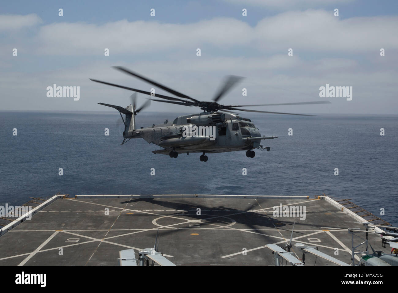 U.S. Marines in a CH-53E Super Stallion with Marine Medium Tiltrotor Squadron 166 Reinforced, 13th Marine Expeditionary Unit (MEU), takes off while at sea aboard the San Antonio-class amphibious transport dock ship USS Anchorage (LPD 23), June 3, 2018. The Essex Amphibious Ready Group (ARG) and 13th MEU are conducting Composite Training Unit Exercise (COMPTUEX), the final exercise before the units’ upcoming deployment. This exercise validates the ARG/MEU team’s ability to adapt and execute missions in ever-changing, unknown environments. Upon completion of COMPTUEX, the 13th MEU and Essex ARG  Stock Photo