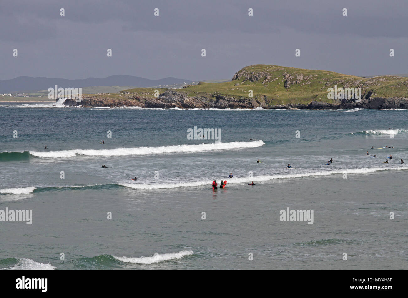 Groups of people surfing in County Donegal Ireland as summer surf schools take place in the Atlantic surf. Stock Photo