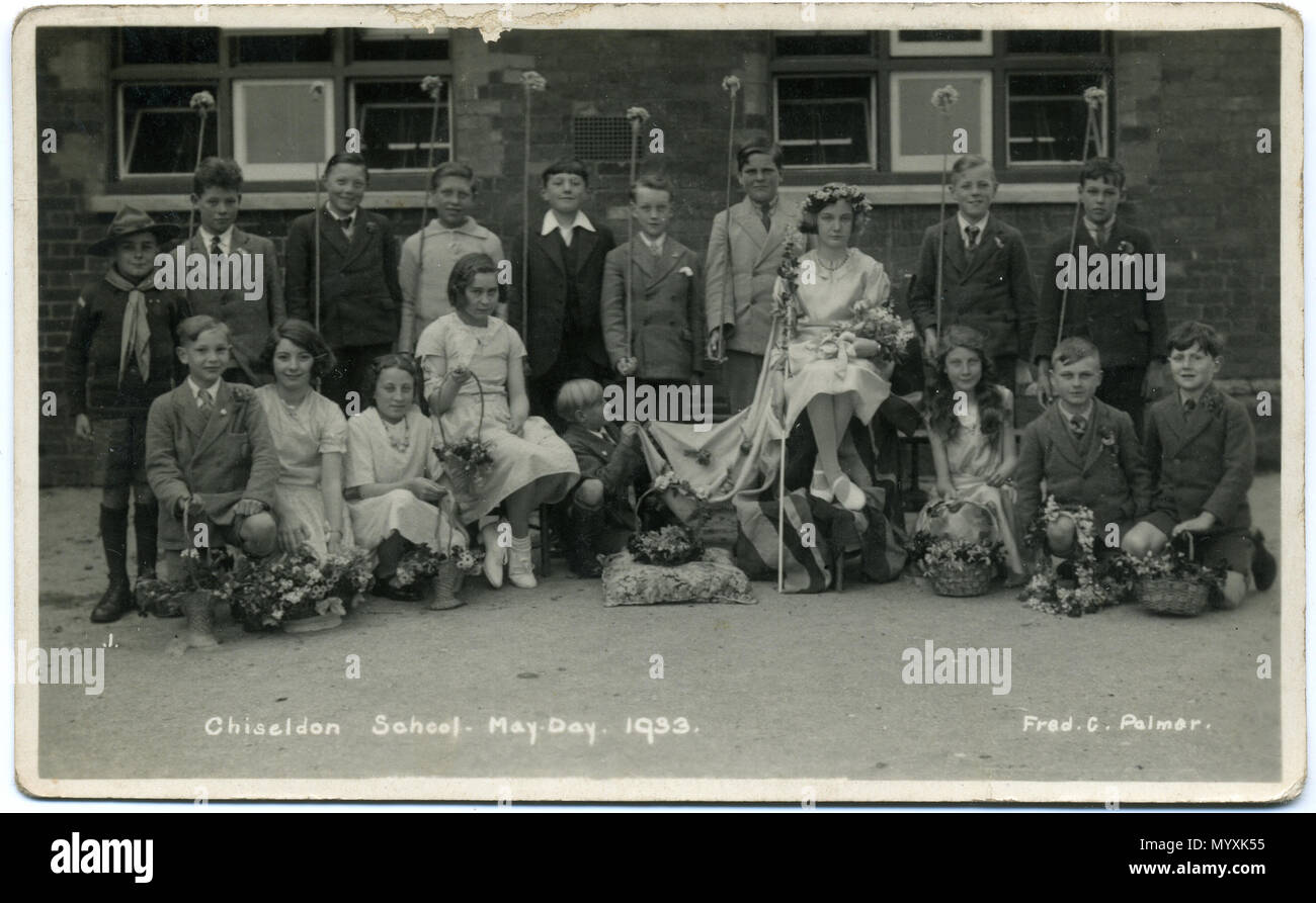 . 1933 postcard of Chiseldon School, near Swindon, Wiltshire, England, showing a group of school children dressed for May Day celebrations. It is one of a set of seven postcards from the 1930s, showing children from the same school on May Day. There is a May Queen; also Brownies, Cubs, Scouts and Girl Guides. The photographer was Fred C. Palmer of Tower Studio, Herne Bay, Kent ca.1905-1920, and of 6 Cromwell Street, Swindon ca.1920-1936. He is believed to have died 1936-1939. This print has darkened with age, but it would be inappropriate to adjust the brightness because detail, e.g. on white  Stock Photo