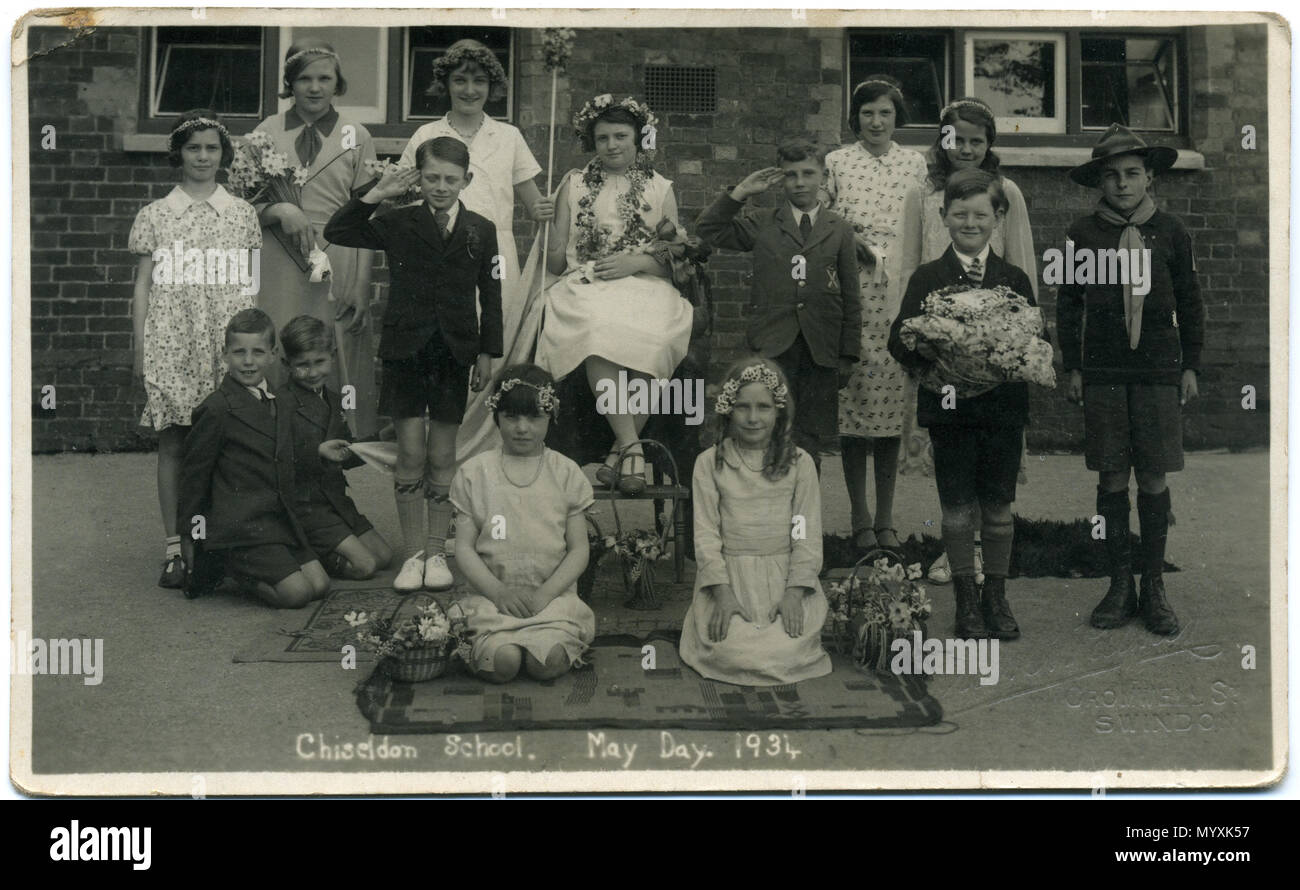 . 1934 postcard of Chiseldon School, near Swindon, Wiltshire, England, showing a group of school children dressed for May Day celebrations. It is one of a set of seven postcards from the 1930s, showing children from the same school on May Day. There is a May Queen; also Brownies, Cubs, Scouts and Girl Guides. The photographer was Fred C. Palmer of Tower Studio, Herne Bay, Kent ca.1905-1920, and of 6 Cromwell Street, Swindon ca.1920-1936. He is believed to have died 1936-1939. This print has darkened with age, but it would be inappropriate to adjust the brightness because detail, e.g. on white  Stock Photo