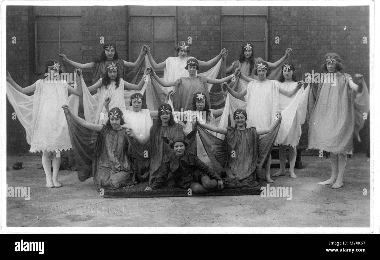 . Postcard photo of schoolgirls dressed for Greek dancing, in or near Swindon, Wiltshire, England. The photographer was Fred C. Palmer of Tower Studio, Herne Bay, Kent ca.1905-1916, and of 6 Cromwell Street, Swindon ca.1920-1936. He is believed to have died 1936-1939. Points of interest  From the 1920s to around the 1960s numerous girls' schools in the UK taught Greek Dancing in the manner of Isadora Duncan. The girls had to wear cotton fabric costumes cut from a pattern designed by Duncan, in a selection of pastel colours as worn by her dancers. The dance movements imitated some of the female Stock Photo