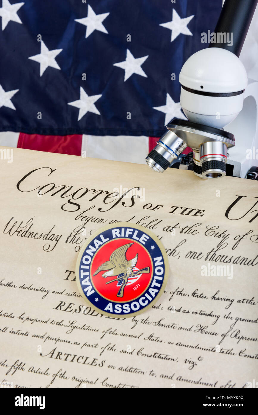 Winneconne - 11 May 2018: The NRA with the US Constitution under a microscope showing the scrutiny the second ammendment is under with the American fl Stock Photo