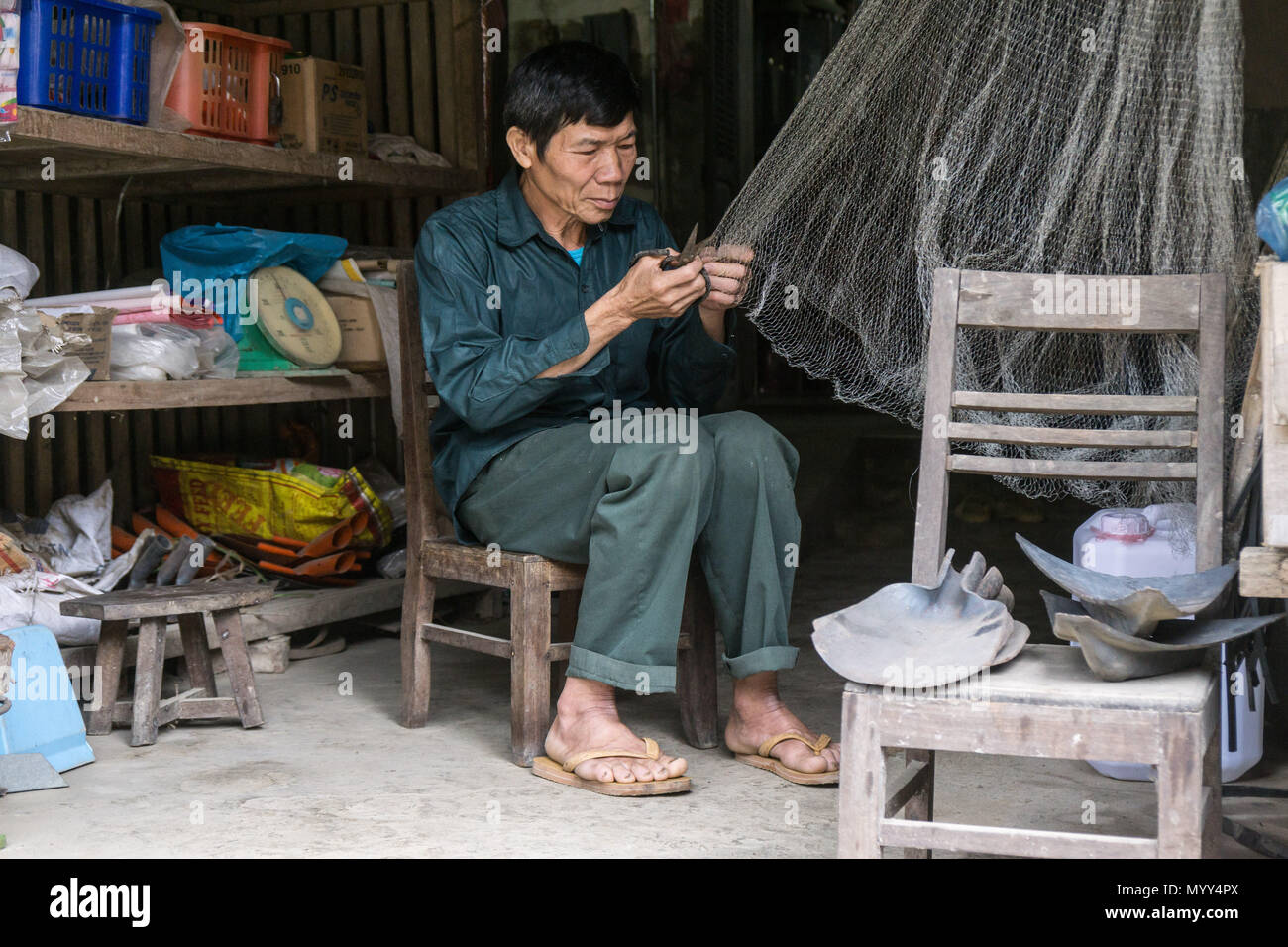 A man repairing fishing nets in Cao Bang Province, North Vietnam Stock Photo