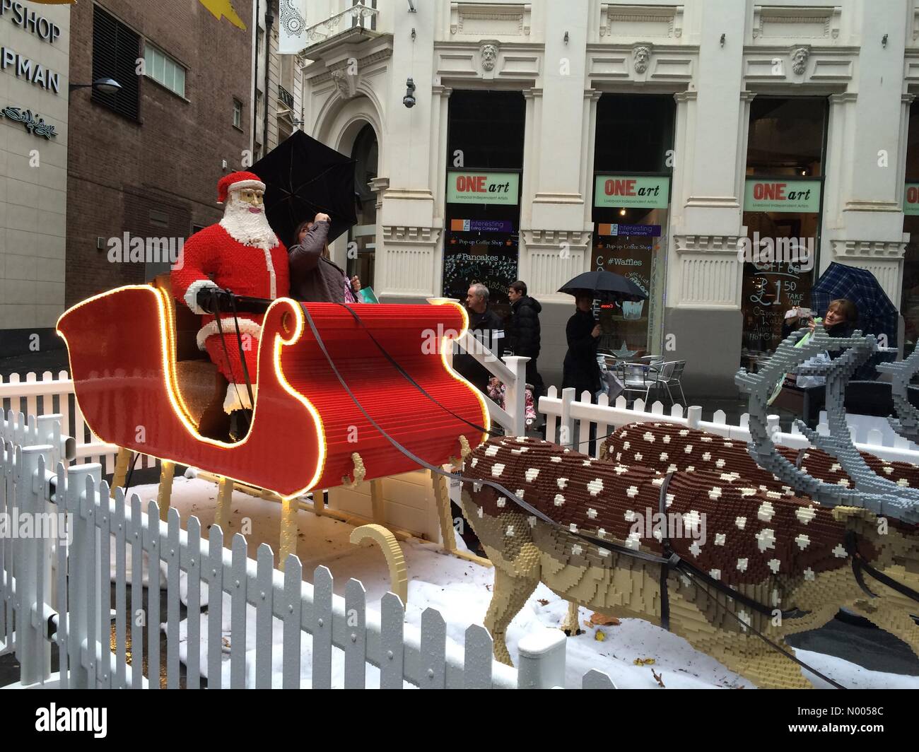 School Ln, Liverpool, Merseyside, UK. 02nd Dec, 2015. UK weather 2nd December 2015 raining on Santa in his sleigh gives a Christmas scene in early December as an umbrella is shared by a passing shopper in Liverpool UK Credit:  Jim Nicholson/StockimoNews/Alamy Live News Stock Photo