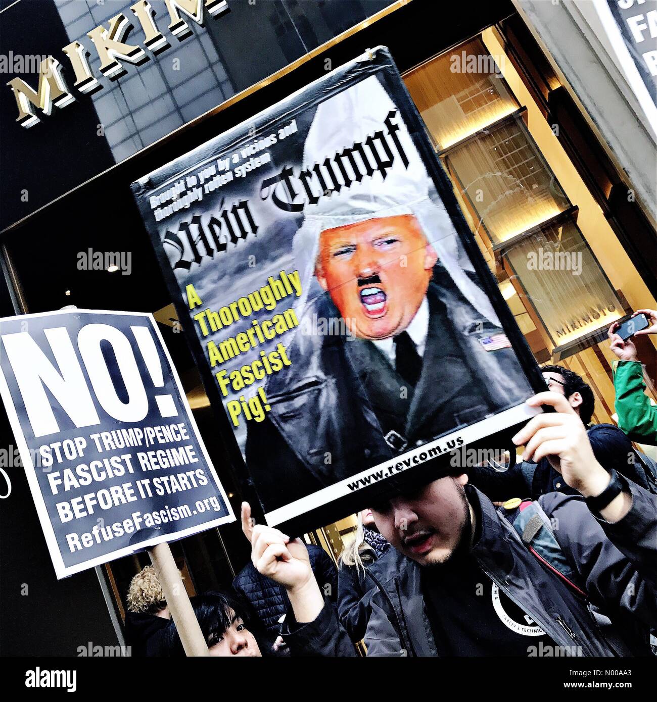 E 57th St, New York, New York, USA. 11th Jan, 2017. A protester holds up a banner outside Trump Tower in New York City as President Elect Donald Trump gives a press conference inside, his first since winning the 2016 US election. © Andy Buchanan1/StockimoNews/Alamy Live News Stock Photo