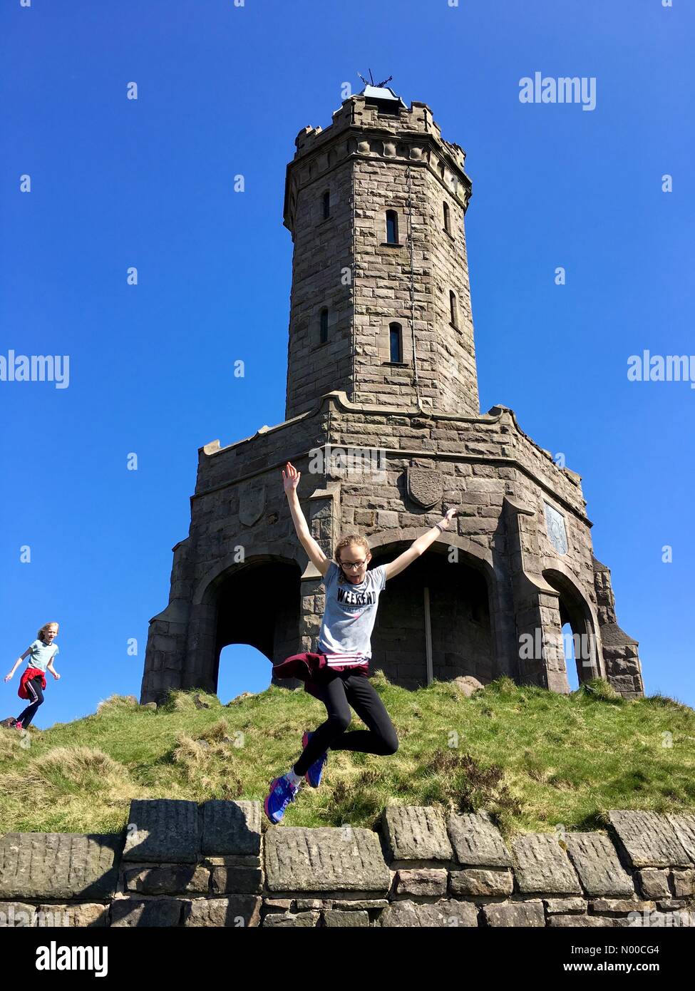 Uk Weather Day In Blackburn Lancashire Two Girls Having Fun In The Sun At Darwen Jubilee Tower On The Moors Above Blackburn Uk Weather Day In Blackburn Lancashire Two Girls Having Fun In The Sun At Darwen Jubilee Tower On The Moors Above Blackburn