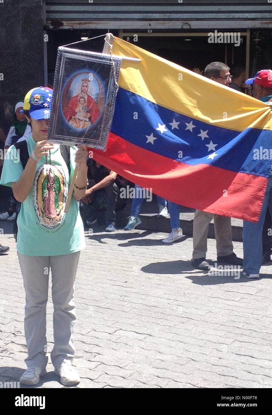 Av Abraham Lincoln, Caracas, Distrito Capital, Venezuela. 17th June, 2017. A young woman holding an image of the Virgen of Coromoto and the Venezuelan flag at a protest against Venezuelan government Credit: Luis Molina/StockimoNews/Alamy Live News Stock Photo