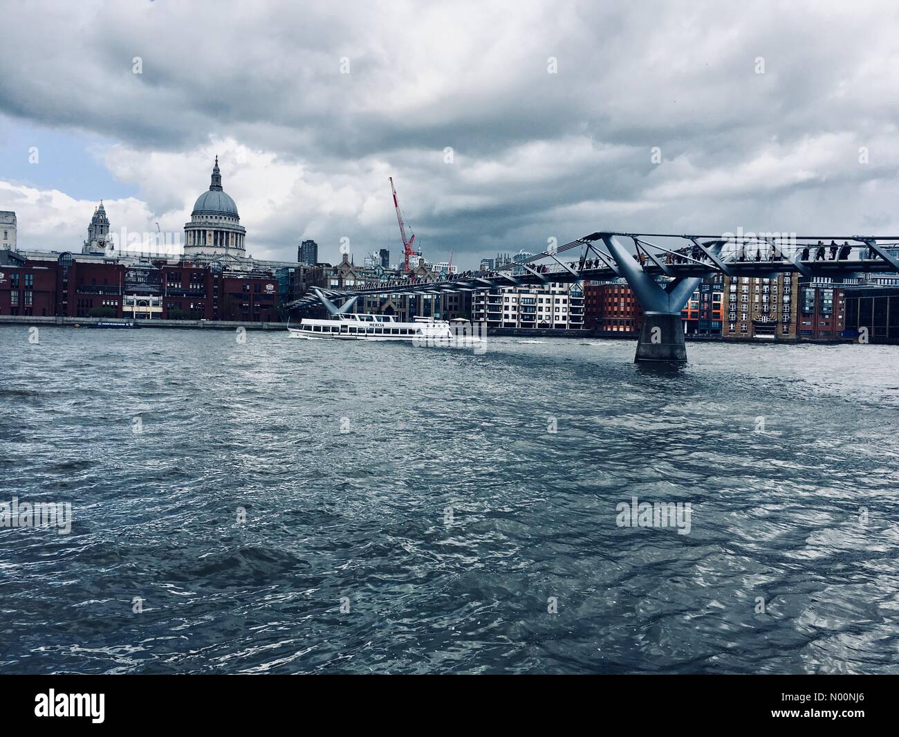 UK Weather - 26 April 2018 A cold and chilly day in London at Millennium Bridge on the River Thames with a view of Saint Paul’s Cathedral. Stock Photo