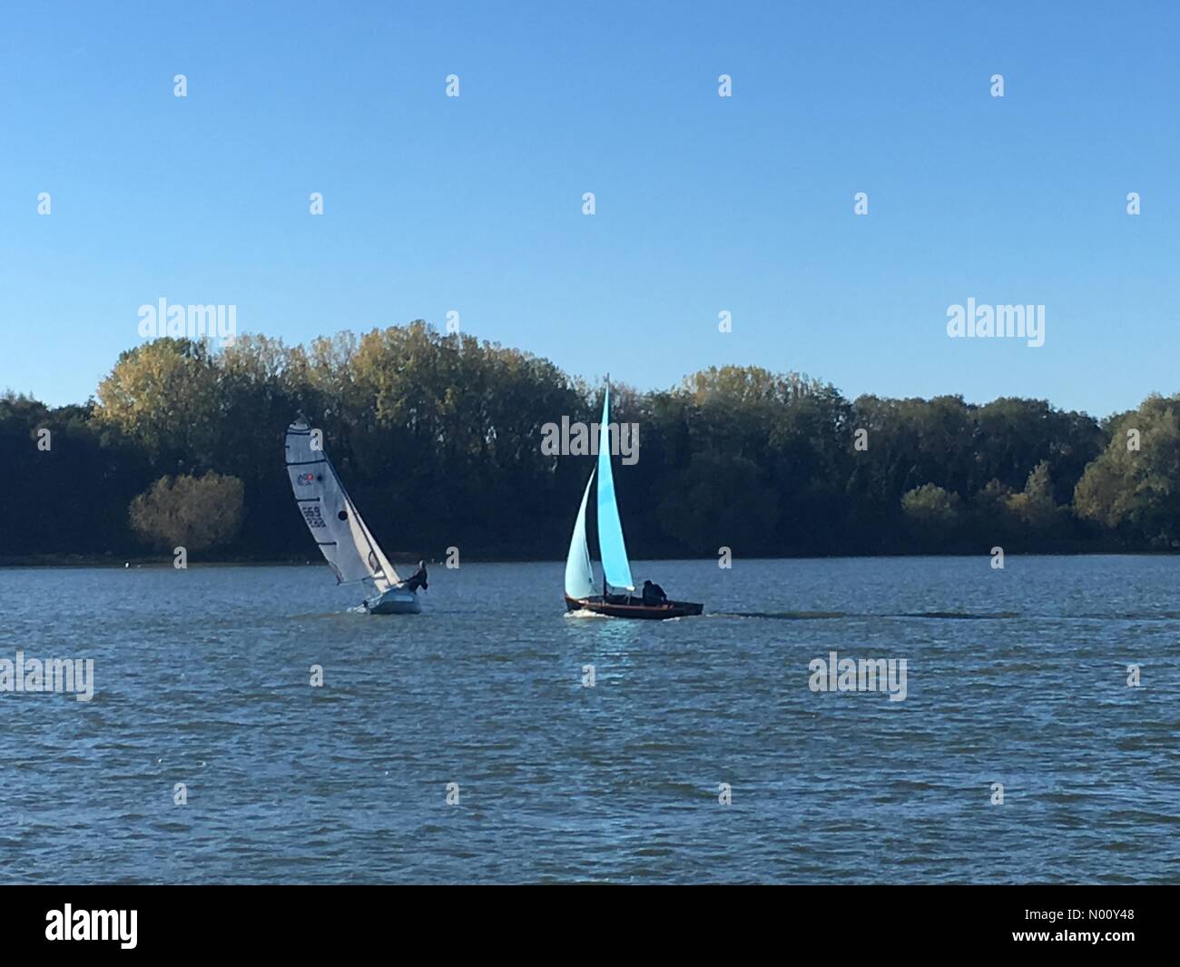 Bedford, UK. 21st Oct, 2018. Dinghy boat racing, with one dinghy tacking to change course, on a really warm sunny Sunday in October on Priory Marina in Bedford, England on October 21, 2018. Albany/Stockimo Live News Martin Parker Credit: Martin Parker/StockimoNews/Alamy Live News Stock Photo