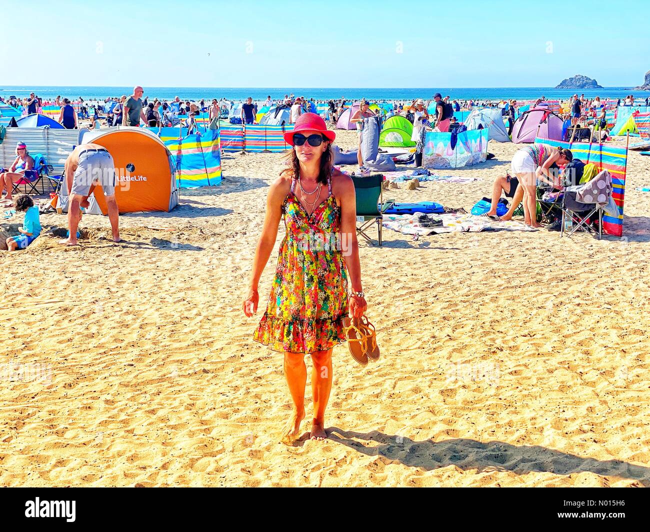 UK Weather: Raich Keene in glorious sunshine on crowded Polzeath beach despite Covid warnings at start of the bank holiday weekend in Cornwall, UK. 27th August, 2021. Credit nidpor/Alamy Live News Credit: nidpor/StockimoNews/Alamy Live News Stock Photo