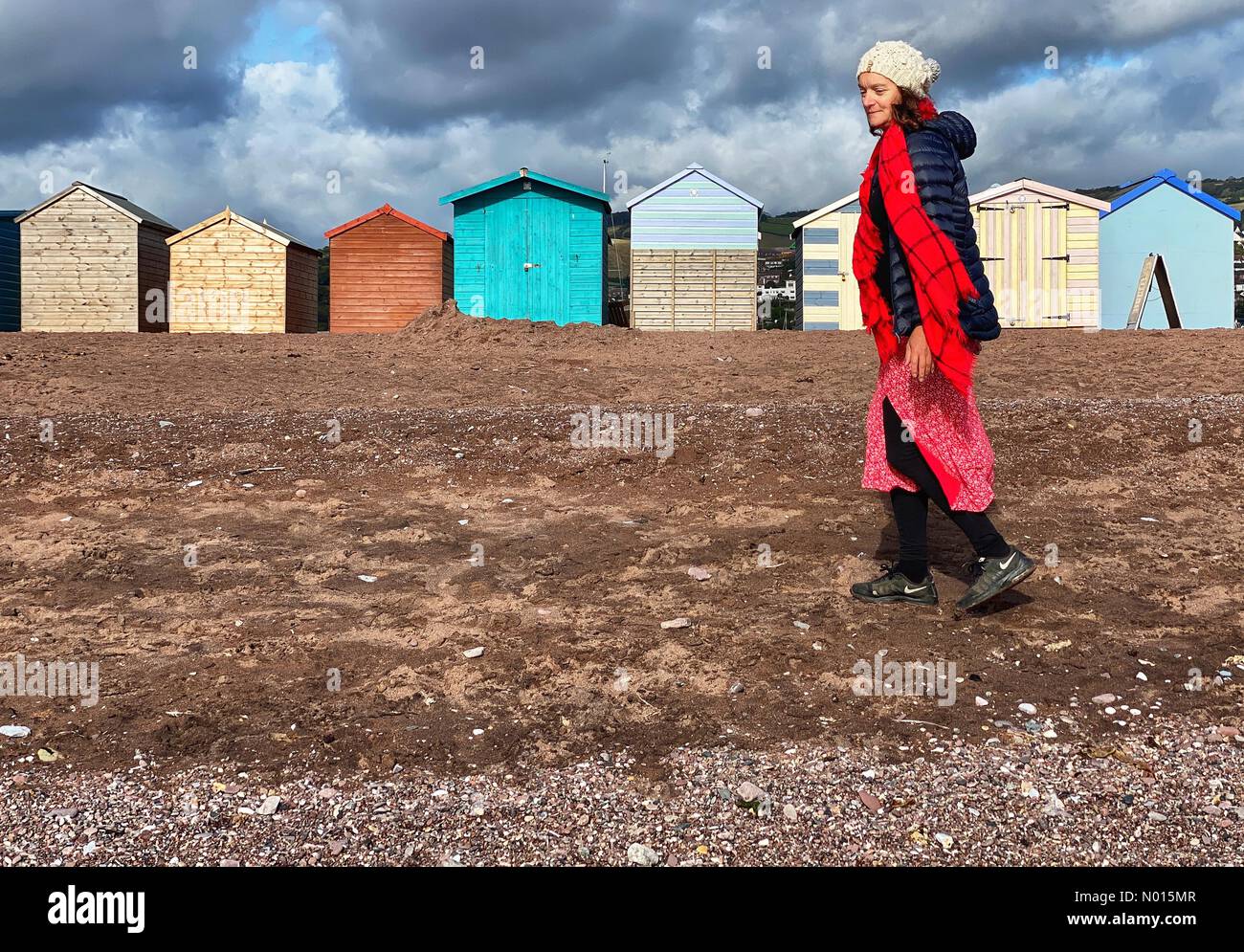 UK Weather: Raich Keene wraps up warm under Clouds over beach huts at Teignmouth in Devon. 1st October, 2021. Credit: nidpor/17�Թ����� Live News Credit: nidpor/StockimoNews/17�Թ����� Live News Stock Photo