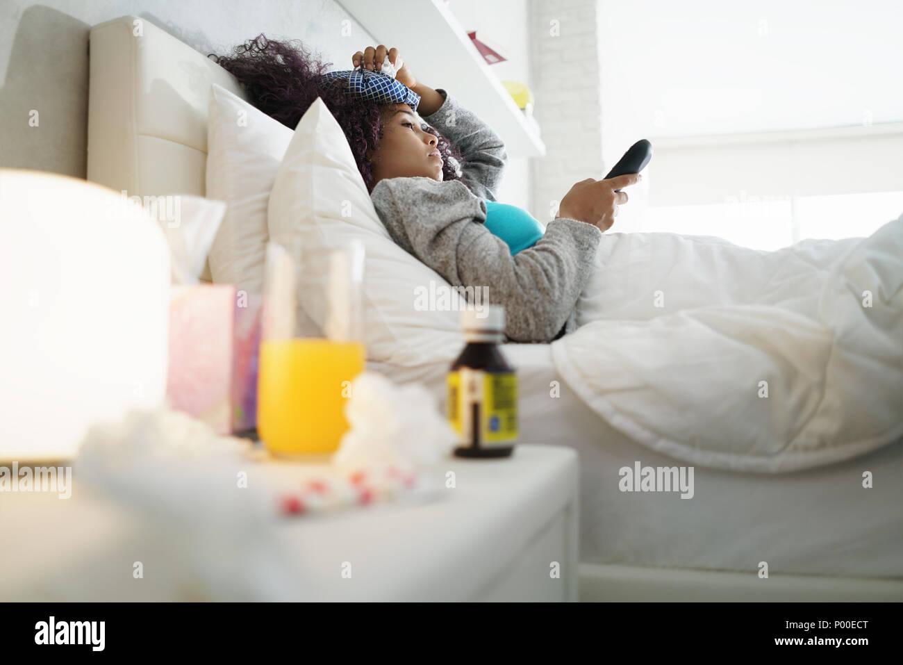 Black Woman With Flu And Cold Watching Tv At Home Stock Photo