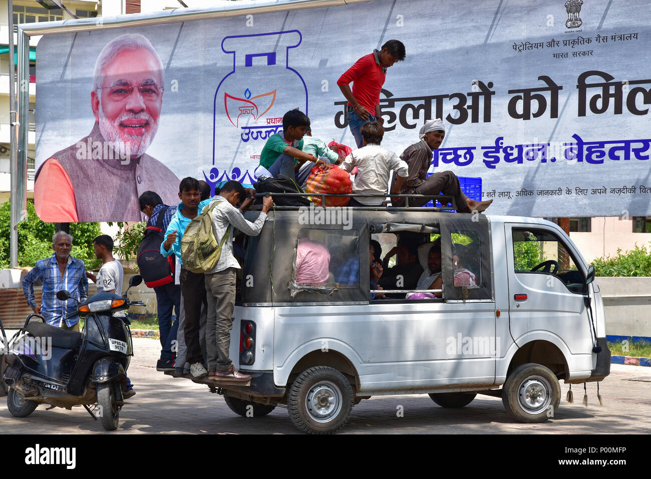 An overloaded car with Modi, the prime minister of India, on the advertisement at the background Stock Photo