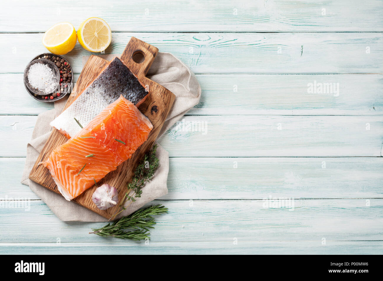Raw salmon fish fillet with spices cooking on cutting board. Top view ...