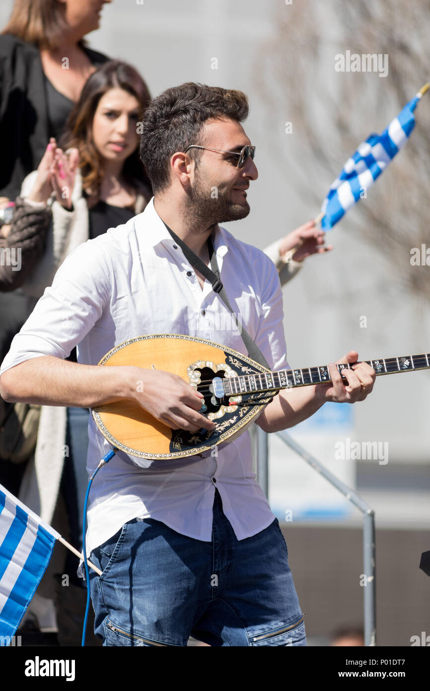 Chicago, Illinois, USA - April 29, 2018 Greek man playing Baglamas during the  Greek Independence  Day Parade Stock Photo