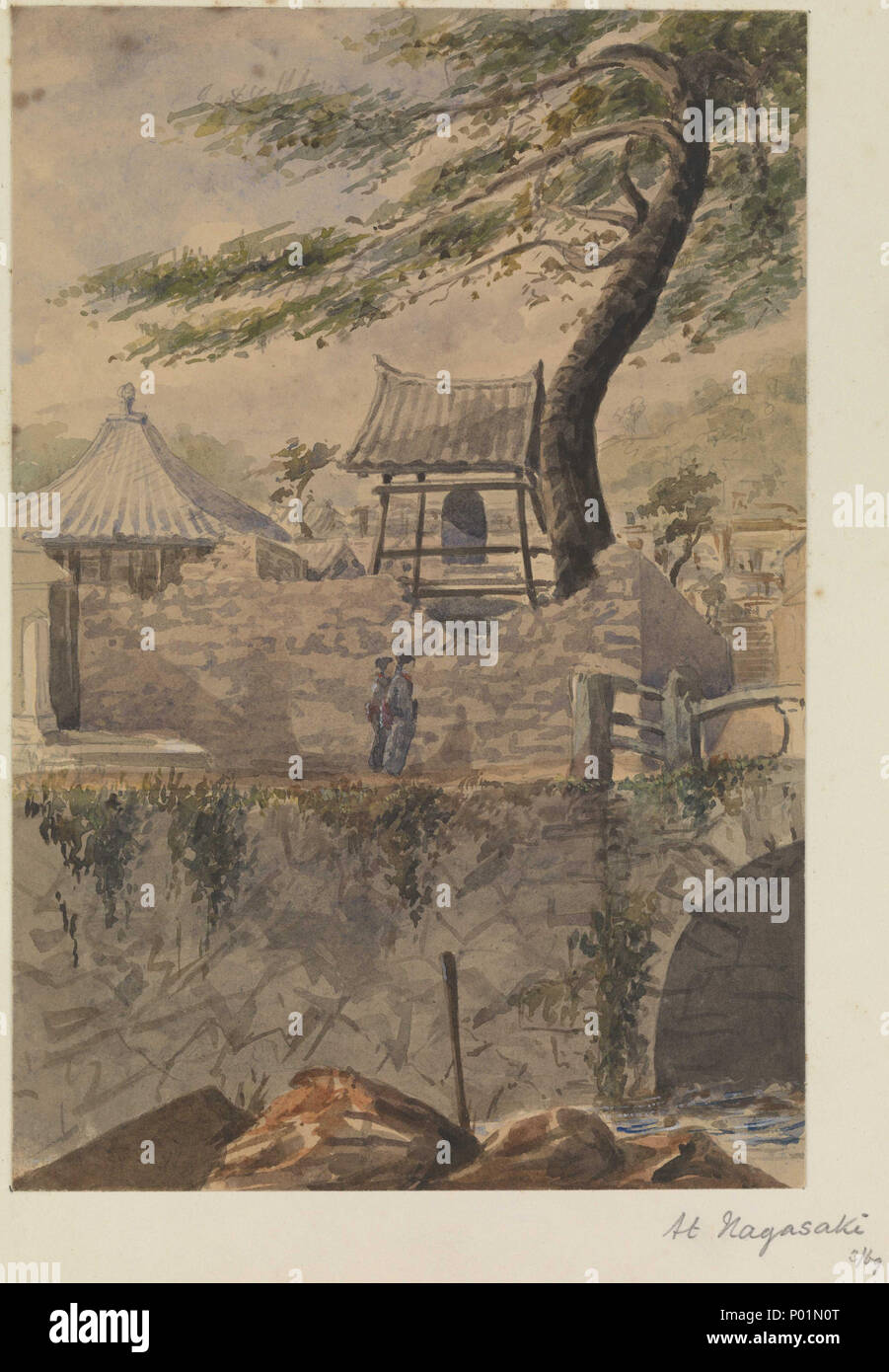 .  English: 'At Nagasaki' [Japan] No. 37 of 51 (PAJ2051 - PAJ2101): inscribed by the artist on the album page, as title and dated '3/69'. The view is across one of the steeply walled local watercourses, with the arch of a stone bridge on the right. On the other side two Japanese figures walk along the roadway outside a Buddhist shrine of which the stone wall has partly collapsed, revealing a belfry with a suspended large bronze bell inside the compound. This stands under the shade of a sinuous large tree. PAJ2068, PAJ2069 and PAJ2086 are also of Nagasaki. At Nagasaki  . March 1869. Lt James He Stock Photo
