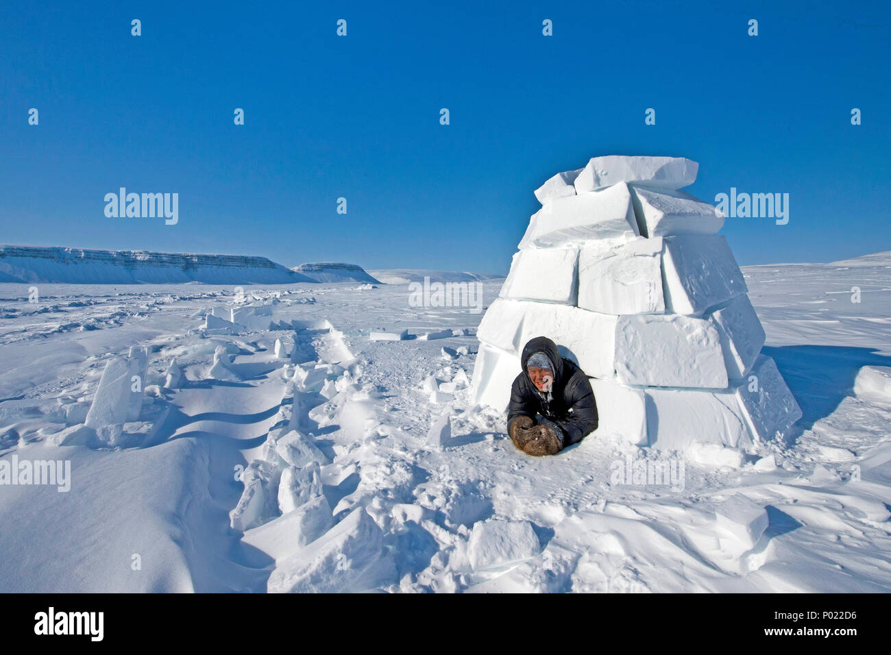 Inuit schaut aus einem Iglu, Nunavut Territorium, Kanada | Inuit looks out of a igloo, Nunavut teritorry, Canada Stock Photo