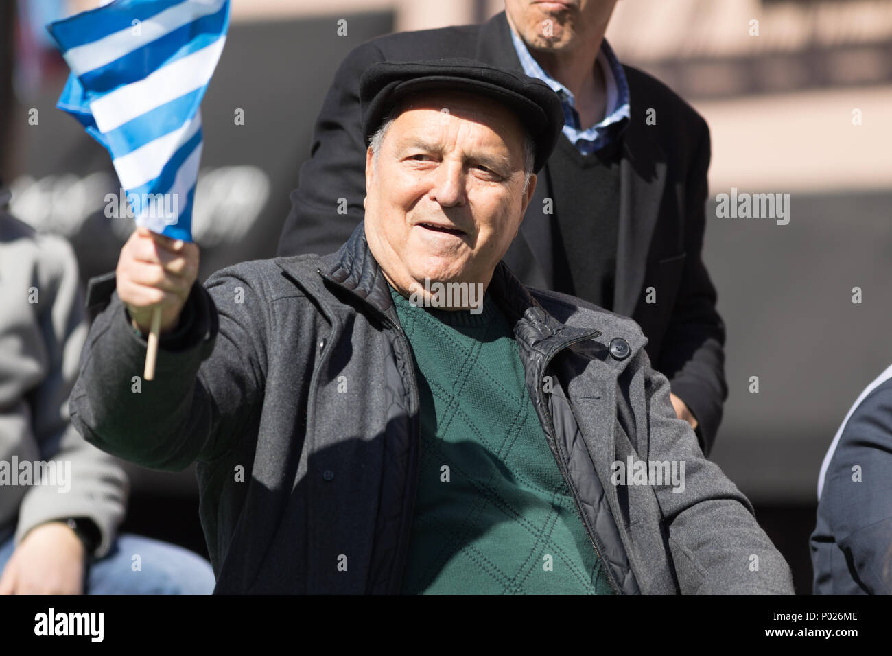 Chicago, Illinois, USA - April 29, 2018 Greek man waving the greek flag at the Greek Independence  Day Parade Stock Photo