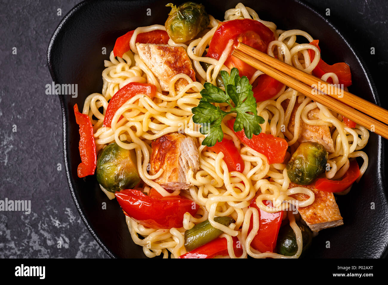 Asian noodles with vegetables and chicken, top view. Stock Photo