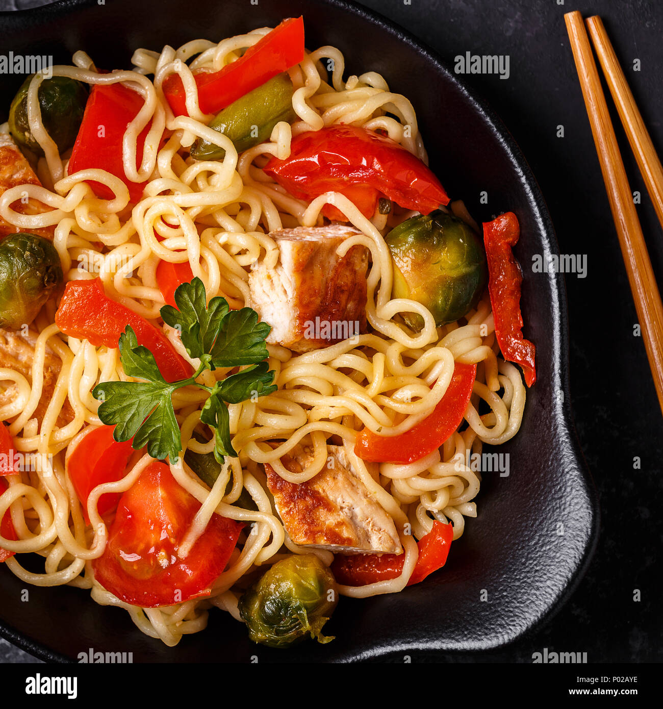 Asian noodles with vegetables and chicken, top view. Stock Photo