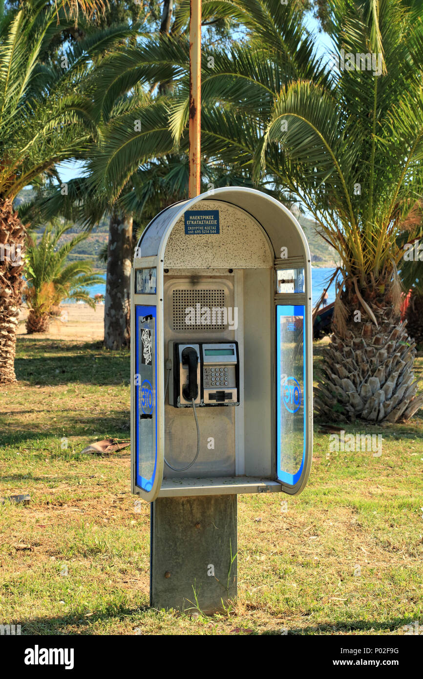Public phone box on palm beach, Greece Stock Photo
