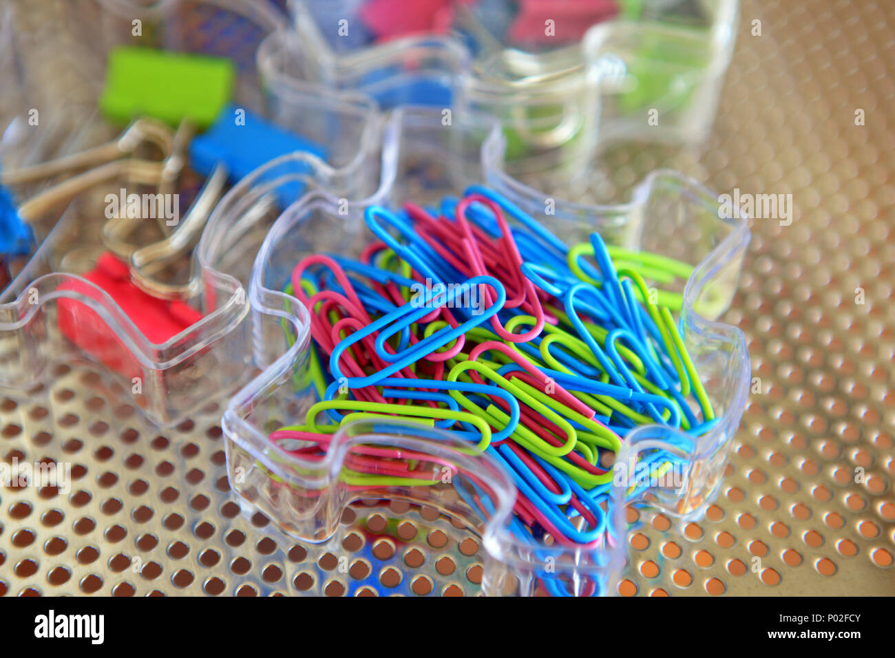 Colourful paper clips and bulldog clips in plastic trays in a home office Stock Photo