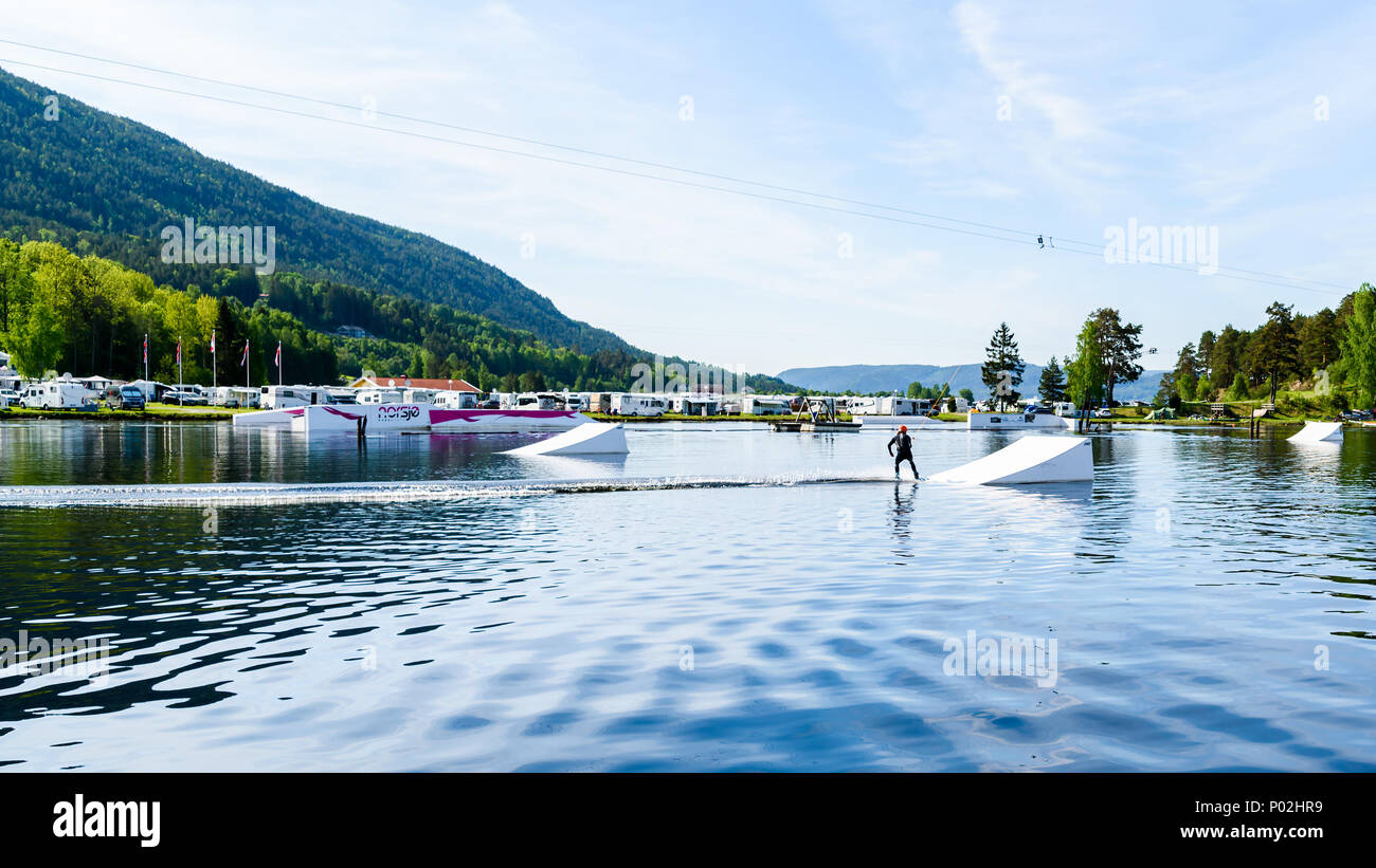 Akkerhaugen, Norway - May 20, 2018: Travel documentary of everyday life and place. Person on a wake park just about to make a jump on a ramp. Camping  Stock Photo