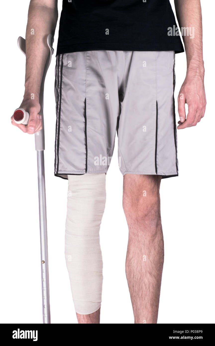 Young guy with a damaged knee bandaged on crutches Stock Photo Alamy