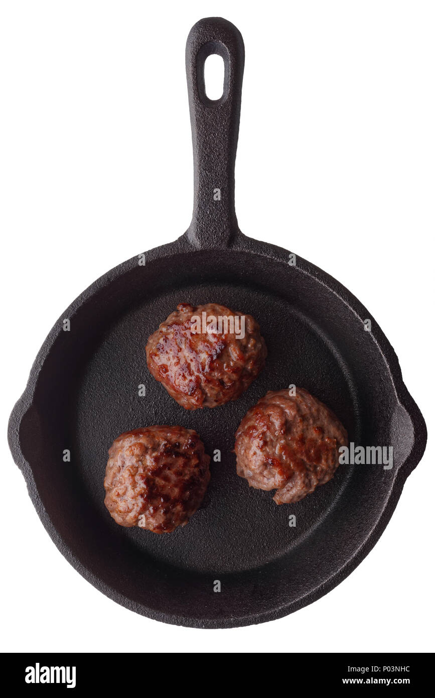 Food: three cooked homemade meatballs on a frying pan, isolated on white background Stock Photo