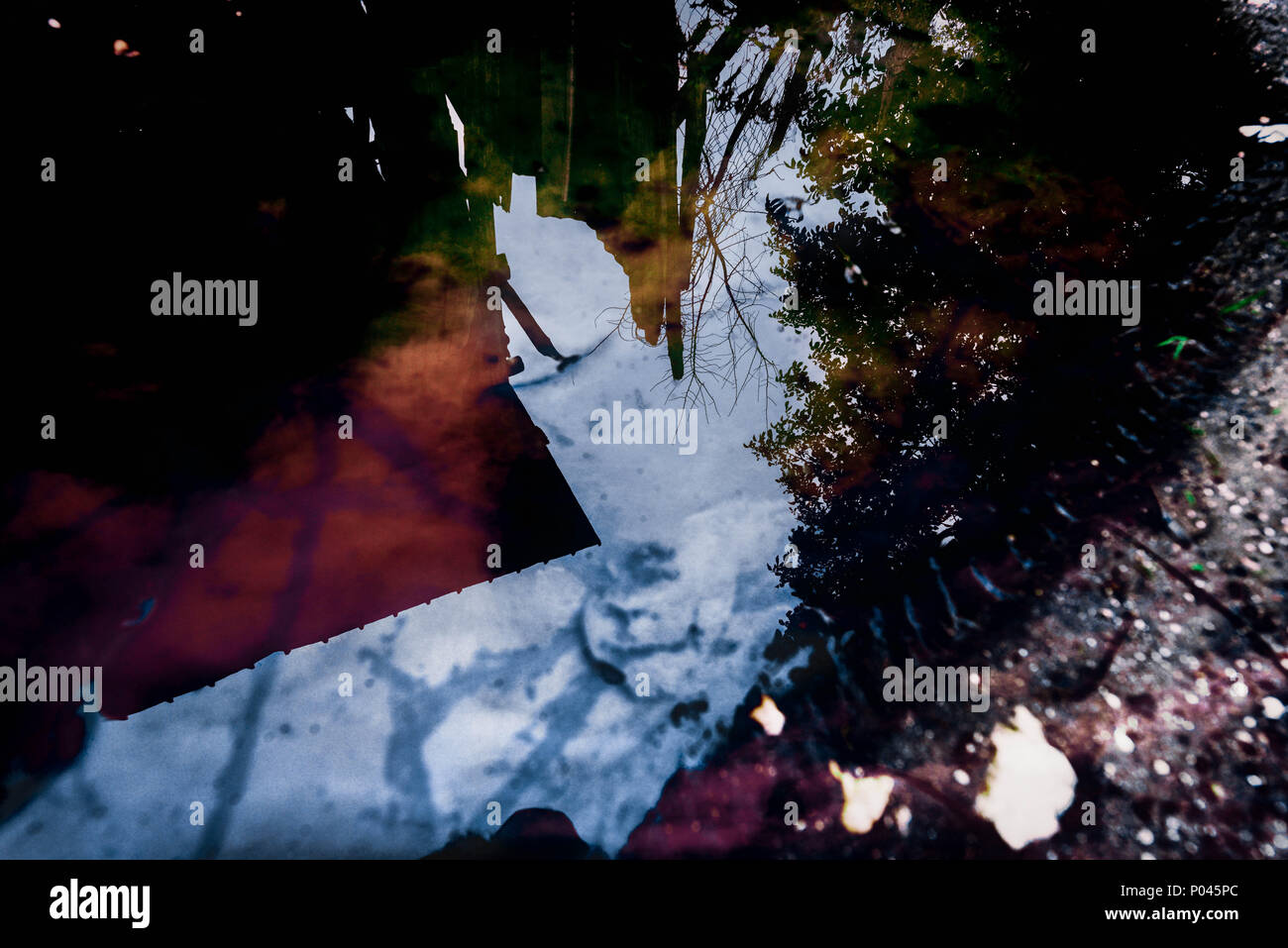 reflex on water with trash items on it Stock Photo