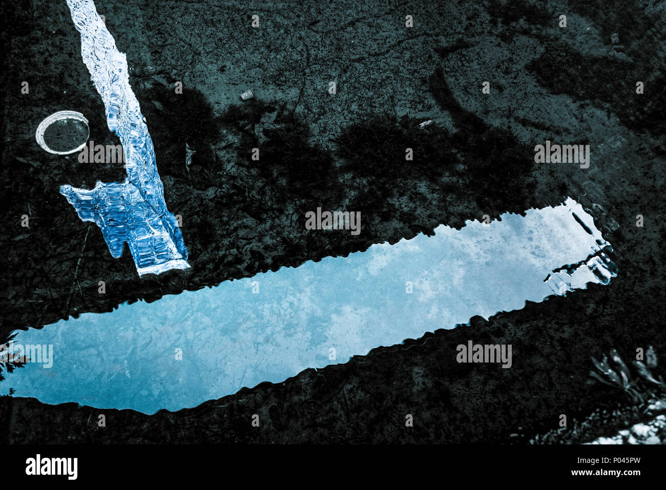reflex on water with trash items on it Stock Photo