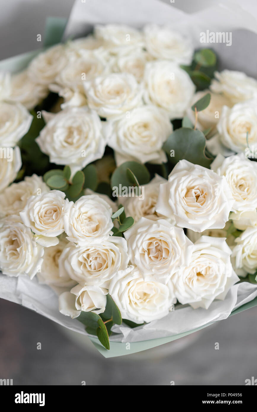 white spray roses. Bouquet of beautiful flowers on wooden table. Floristry  concept. the work of the florist at a flower shop. Vertical photo Stock  Photo - Alamy