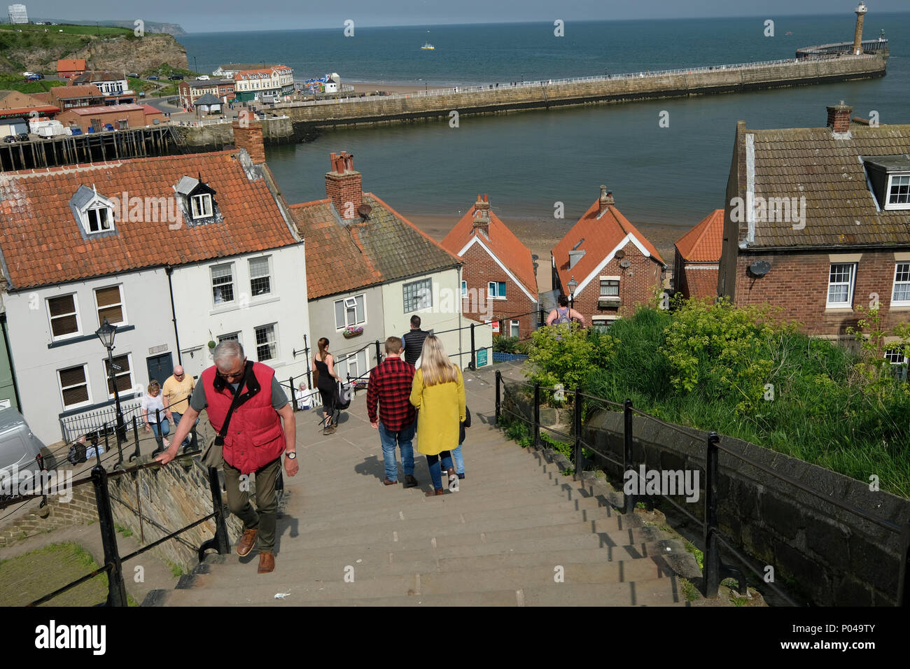 Visitors to Whitby climbing the 199 steps up to the Abbey Stock Photo ...