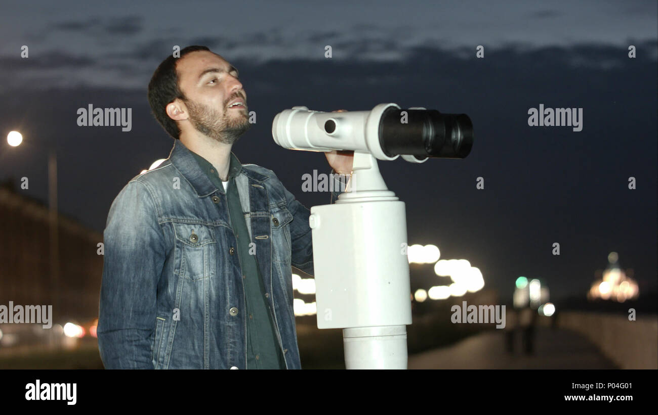 Man using a coin operated telescope enjoying a great view of the city