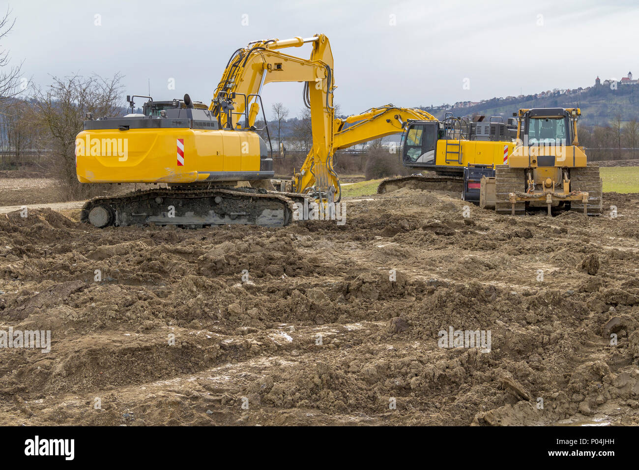 two yellow excavators at a loamy construction site Stock Photo - Alamy