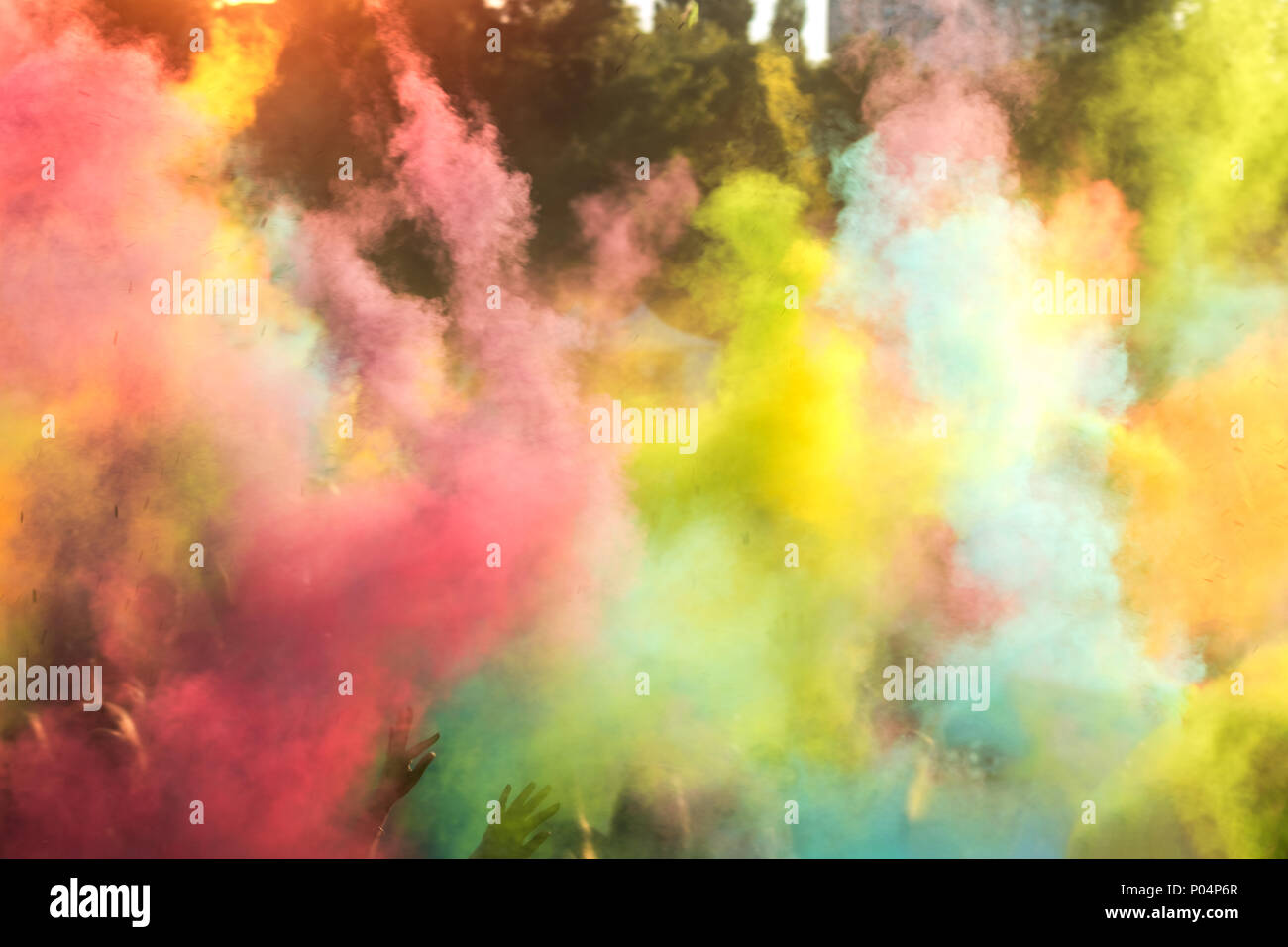 People dancing during Colorful Holi Festival. Blurred sunny sunset  multicolor background Stock Photo - Alamy