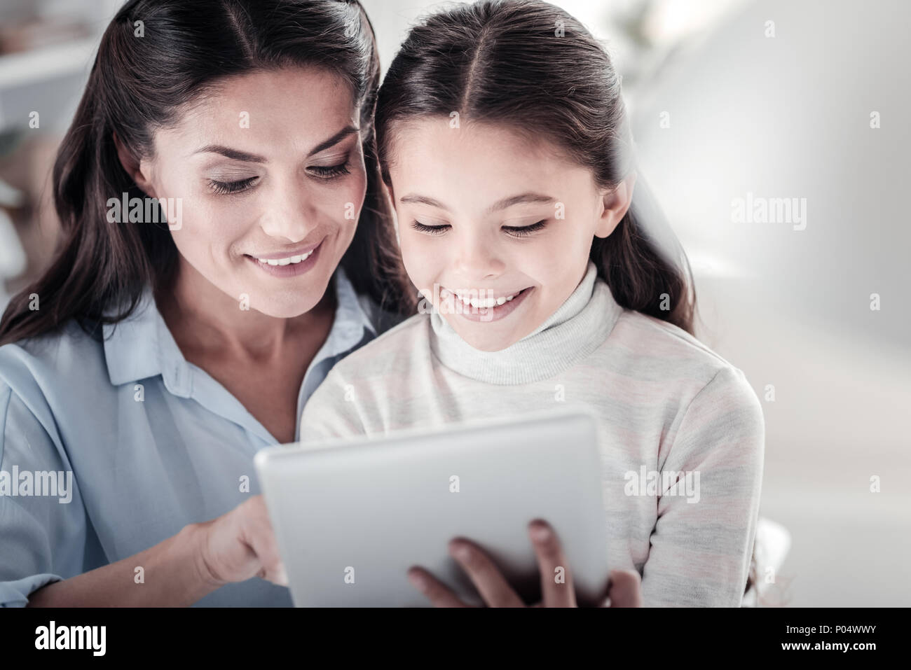 Portrait of delighted girl that staring at tablet Stock Photo