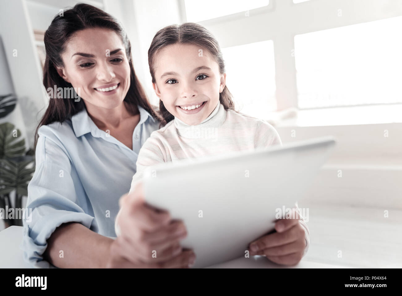 Positive delighted brunette woman embracing her daughter Stock Photo