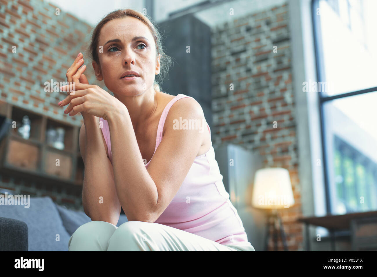 Musing mature woman experiencing helplessness Stock Photo