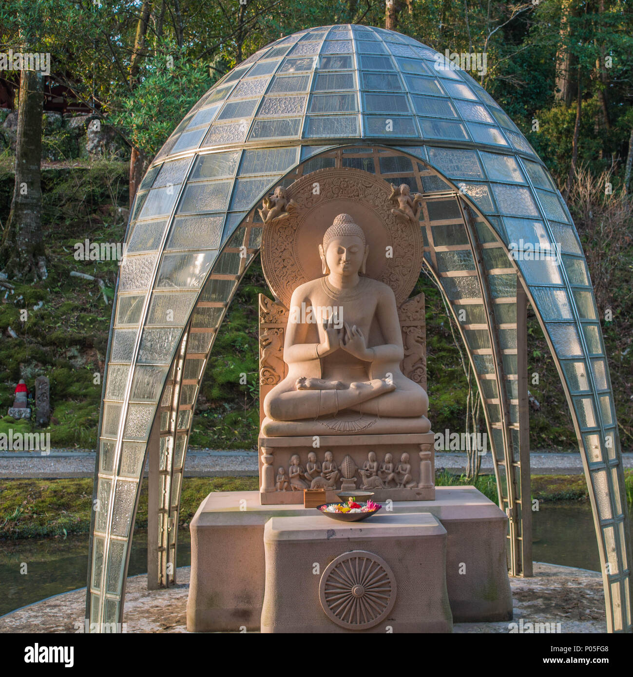 Buddhist statue, under glass tile dome, with offerings of flowers, Chikurinji temple 31, Shikoku 88 temple pilgrimage,  Kochi, Japan Stock Photo